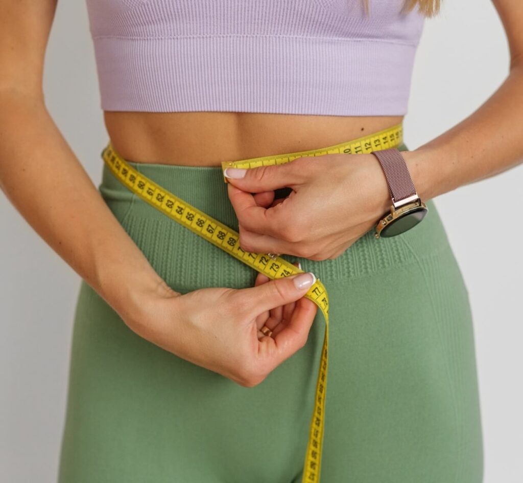 slim-woman-measuring-her-waist-by-measure-tape-cl-2023-11-27-05-08-12-utc (1)